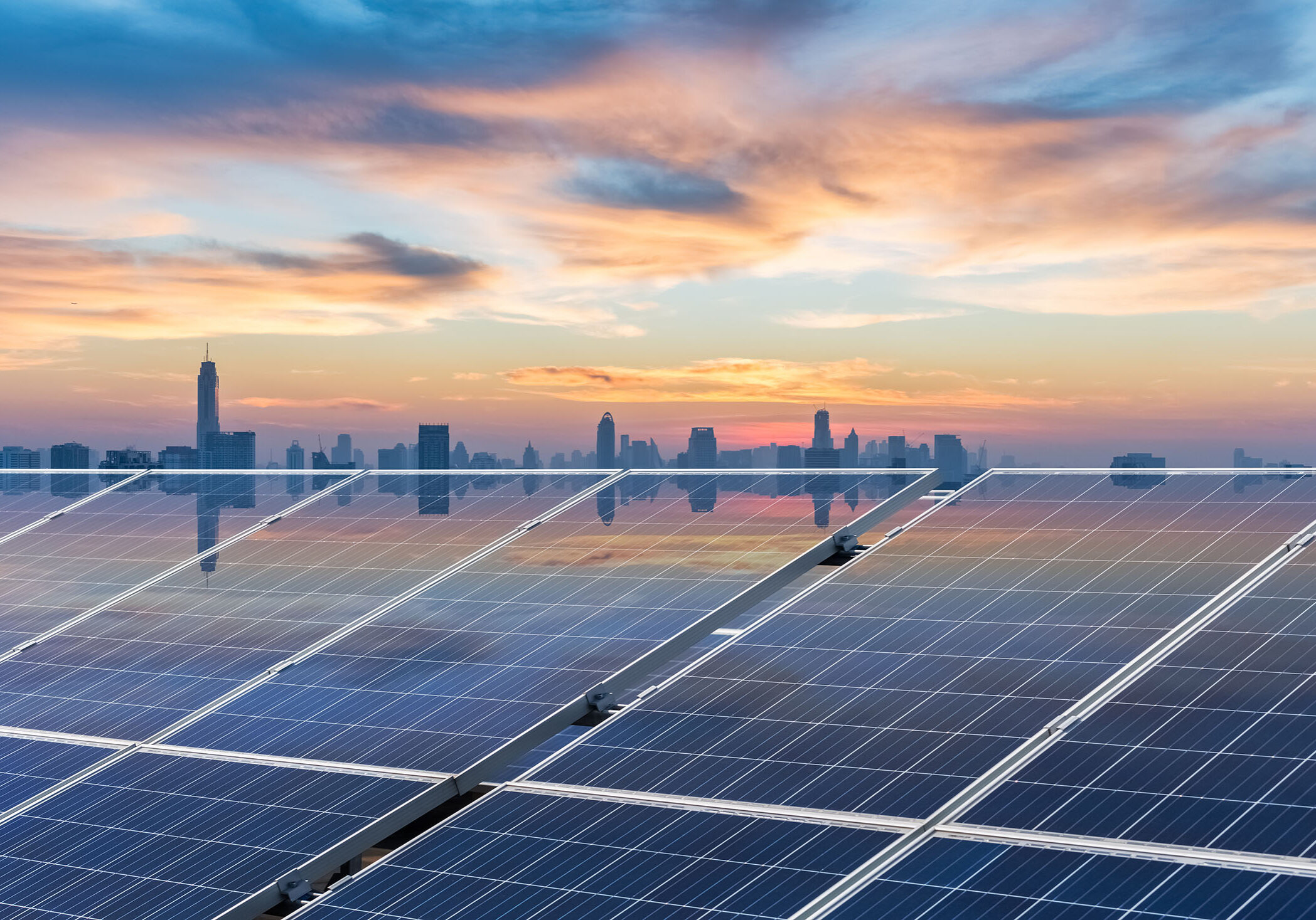 sunset glow reflected on solar panels with bangkok skyline